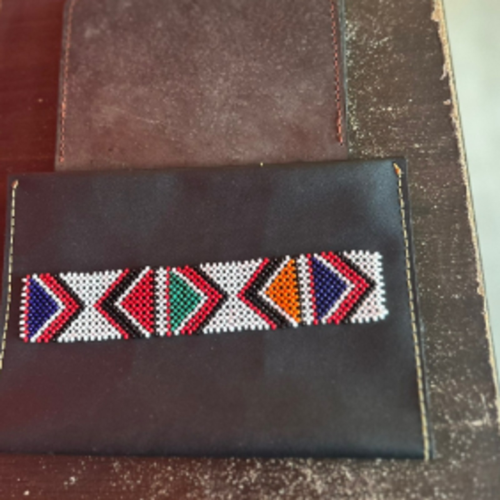 Dark full-grain leather wallet with a horizontal band of Maasai beadwork